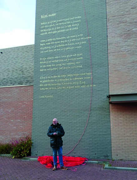 Kunstenaar Freddy Hoevers heeft het gedicht op de muur aangebracht.jpg