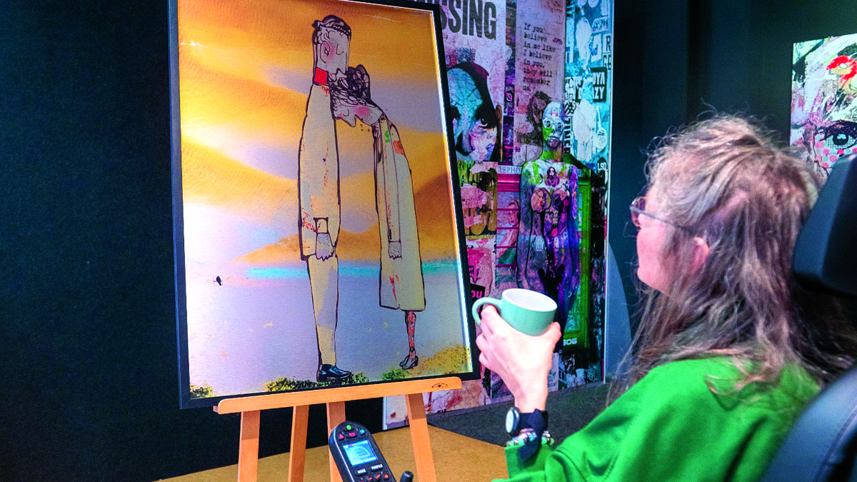 Floortje kijkt met een kop koffie in de hand naar haar kunstwerk Foto Björn van den Elst.JPG