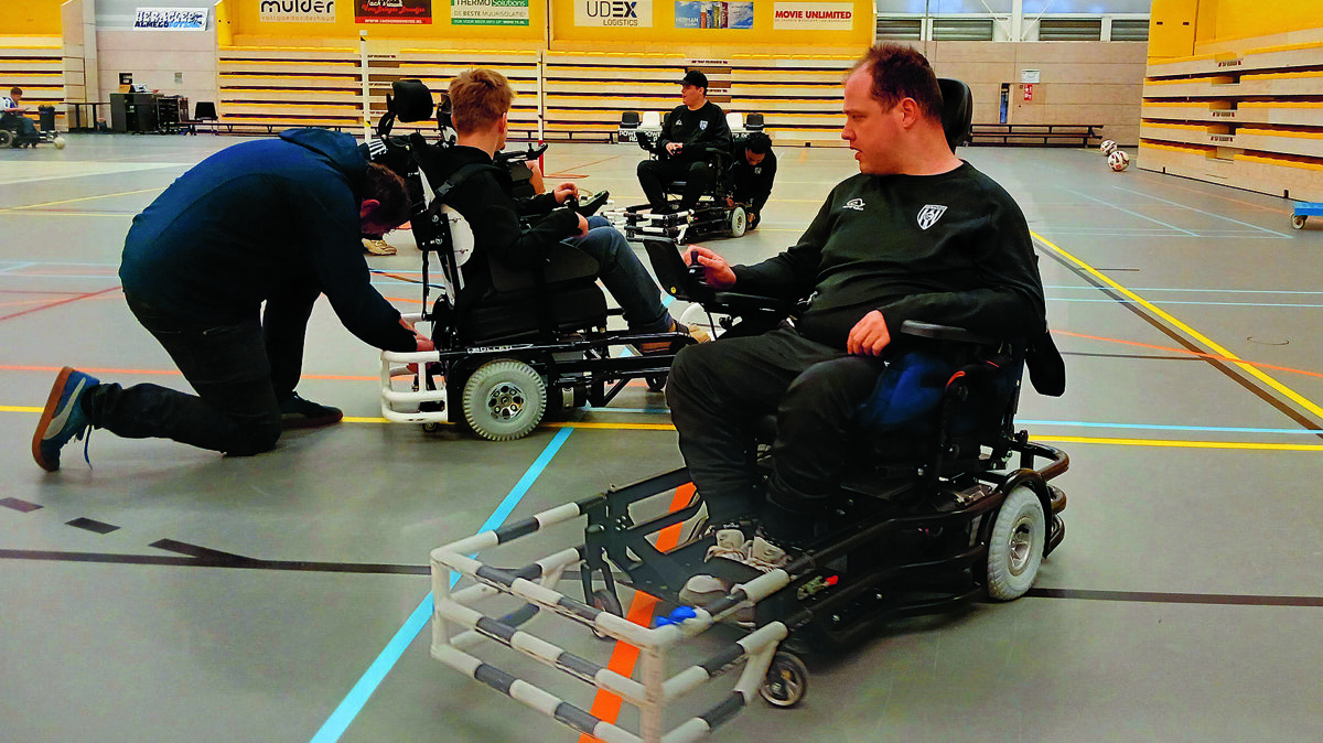 vrijwilligers helpen bij het goed in de stoel zetten. Het spel is heel dynamisch.jpg