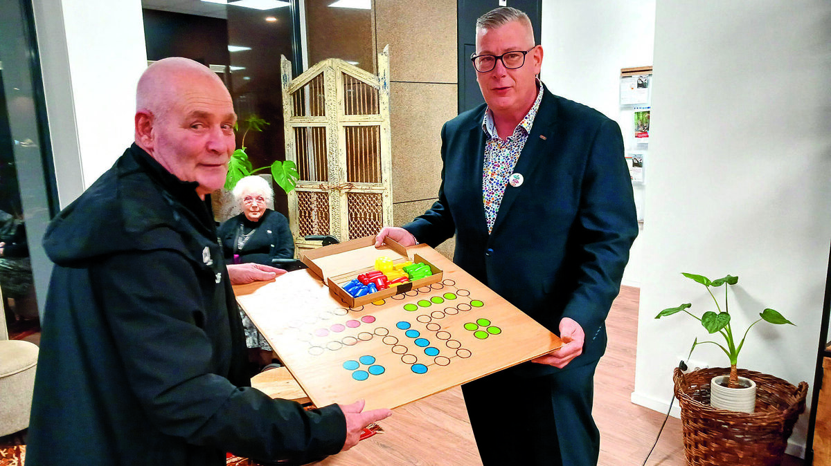 Beszoeker laat trots zijn eigen gemaakte Mens erger je niet spel zien.jpg